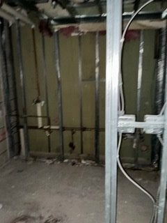 Wet-wall framing and plumbing rough-in during a hotel bathroom renovation